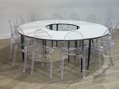 a round table with clear chairs around it