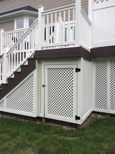 a white fence and some steps in front of a house with grass on the ground