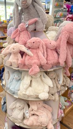 several stuffed animals are stacked on top of each other in a toy store display case