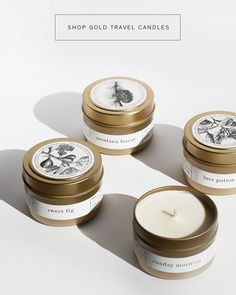 three candles sitting next to each other on top of a white surface with the words, shop gold travel candles