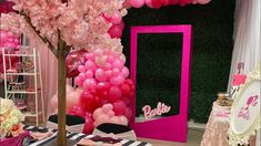 a pink and white party with balloons, decorations and table cloths in front of a mirror