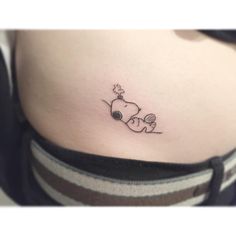 a woman's stomach with a small tattoo of a dog sleeping on her belly