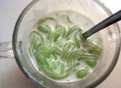 a cup filled with green liquid on top of a table