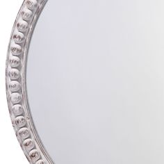 a round mirror with shells in the middle and an oval frame around it, on a white background