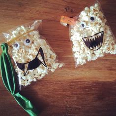 two bags filled with popcorn sitting on top of a wooden table