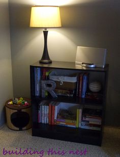 a book shelf with books and a lamp on top