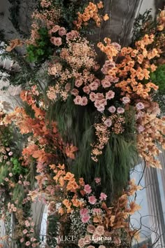 an arrangement of flowers hanging from the ceiling