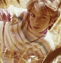 a woman in striped shirt laying on the ground