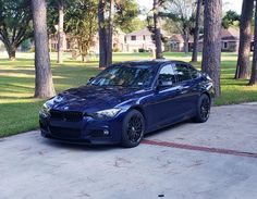 a blue car parked in front of some trees