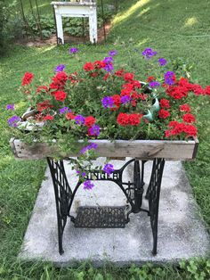 an old sewing machine with flowers growing out of it