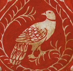 a red and gold bird painted on the side of a wall