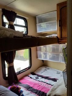 a bunk bed in the corner of a room with windows and curtains on both sides