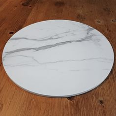 a white marble plate sitting on top of a wooden table