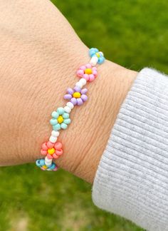 a woman's arm with a bracelet made out of colorful beads on the wrist