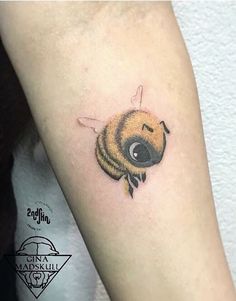 a small bee tattoo on the arm