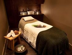 a massage room with candles and towels on the bed