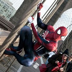 a man dressed as spider - man in the middle of a street with people looking on