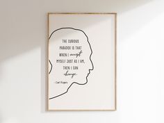 a framed poster with a quote on it in the corner of a room next to a plant