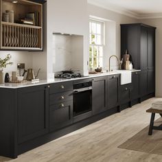 a large kitchen with black cabinets and white counter tops is pictured in this image from the front view