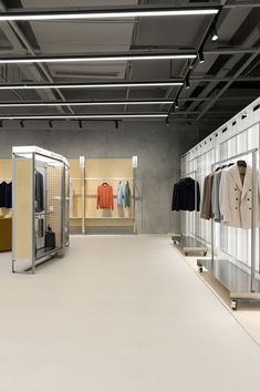 the inside of a clothing store with clothes on racks