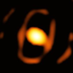 a blurry image of an orange object in the dark sky with light coming from it