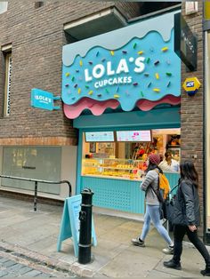 two people walking past a store front on a city street with lots of ice cream