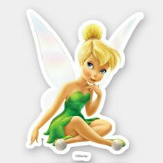 a tinkerbell fairy sitting on the ground with her hand under her chin and looking at the camera