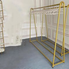 two racks with clothes hangers in an empty room