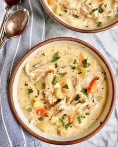 two bowls of chicken noodle soup with spoons