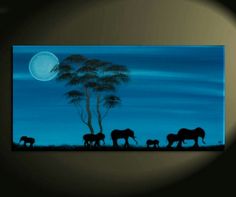 an elephant family silhouetted against the night sky with full moon in the back ground