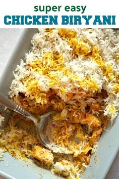 rice and other food in a blue dish with a spoon on the side next to it