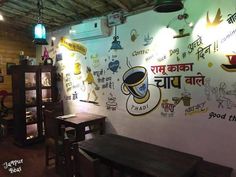 the interior of a restaurant with many signs on the wall and wooden tables in front of it