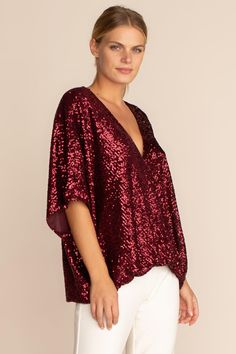 One of our most flattering silhouettes, the Concourse top is back in glittering ruby-colored sequins. Featuring a low surplice neckline and fluttery, dolman sleeves, this sparkling top is perfect for a holiday get-together at home or away. Surplice neckline Dolman sleeves Model in Garnet Red 5'10", wearing size M Model in Emerald Green is 5'10", wearing size S All That Glitters Sequins Dry Clean Only Imported Semi Formal Christas Blouses, Sequin Holiday Shirts, Cheap Red Festive Blouse, Cheap Long Sleeve Shirt For Festive Occasions, Cheap Festive Evening Tops, Luxury Red Sequined Blouse, Luxury Festive Sequined Blouse Piece, Luxury Festive Sequin Blouse, Glitter Plus Size Tops