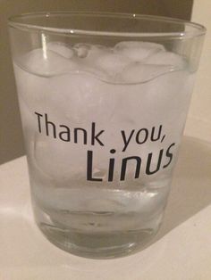 a glass filled with ice sitting on top of a counter next to a sign that says thank you, linus