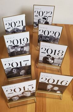 four clear acrylic frames with black and white photos in them on a wooden table