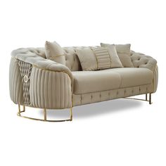 a beige couch with pillows on it and some gold trim around the armrests