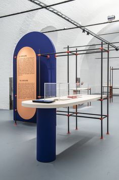 a table with some glasses on it in front of a blue and orange display case