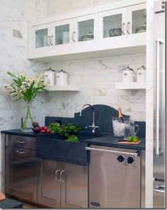 a kitchen with stainless steel appliances and marble counter tops