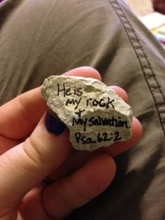 someone is holding a rock with the words his rock my salvation written on it in black ink