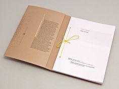 an open book with a yellow ribbon on the front and back cover, sitting on top of a table