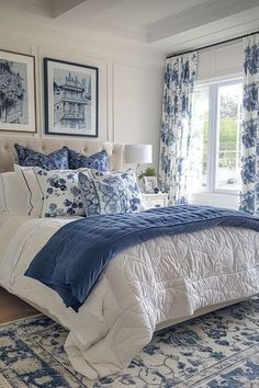 a bed with blue and white comforter in a bedroom next to a window filled with curtains