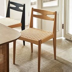 two wooden chairs sitting next to each other on top of a carpeted floor in front of a door