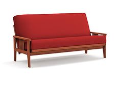 a red couch sitting on top of a white floor next to a wooden frame and arm