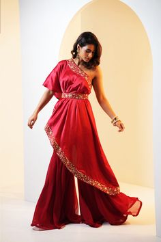 Introducing the stunning Seher Drape Cape and Flared Pants Set – a true masterpiece of traditional Indian design and modern elegance! This exquisite set features a beautiful red flared sharara pants in chiffon fabric, paired with an embroidered satin one-shoulder cape. The outfit is completed with an embroidered waist belt and an inner satin bustier, adding a touch of glamour and sophistication to the overall look.
The intricate hand embroidery on the cape showcases the impeccable craftsmanship Georgette Sharara, Sharara Pants, Satin Bustier, Red Flare, Satin Hands, Embellished Belt, Beads Work, Embroidered Belt, Sharara Set