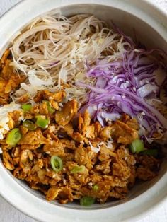 a white bowl filled with meat and veggies