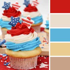 cupcakes with red, white and blue frosting on them sitting on a table