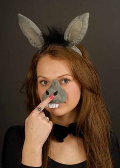 a woman wearing bunny ears and holding a pencil in her mouth while making a funny face