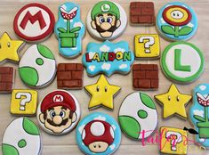 decorated cookies are arranged on a table with mario's name and other items in the background