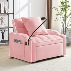 a pink chair with two pillows on top of it in front of a bookshelf