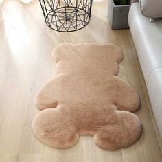 a teddy bear rug is on the floor next to a chair and potted plant